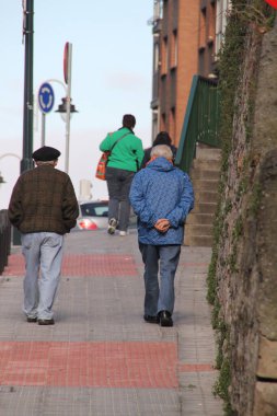 Sokakta yürüyen yaşlı insanlar.
