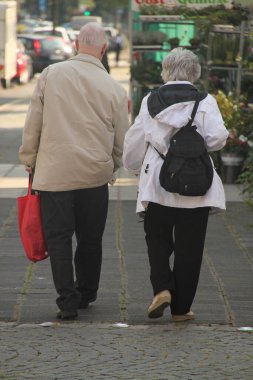 Sokakta yürüyen yaşlı insanlar.