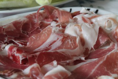 Bir tabakta dilimlenmiş jambon
