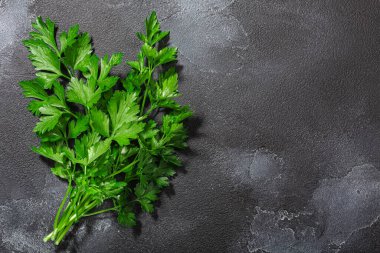 Düz yapraklı Maydanoz (Petroselinum crispum) yaprakları koyu desenli arkaplan arkaplanı üzerinde, üst görünüm