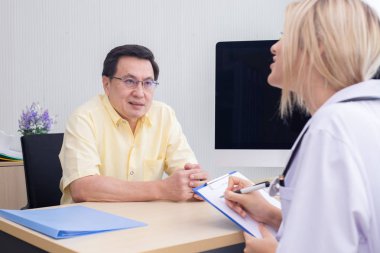 Erkek hasta ve doktor Kadın hastanede masada tartışıyor