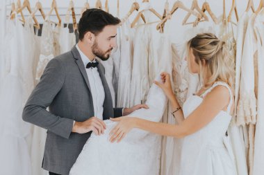 Damat gelinin gelinlik giymesine yardım ediyor..