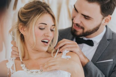 damat sürpriz giyen gelin için kolye koymak.