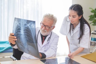 Kıdemli erkek doktor kadın doktor ziyaret radyolog f veriyor