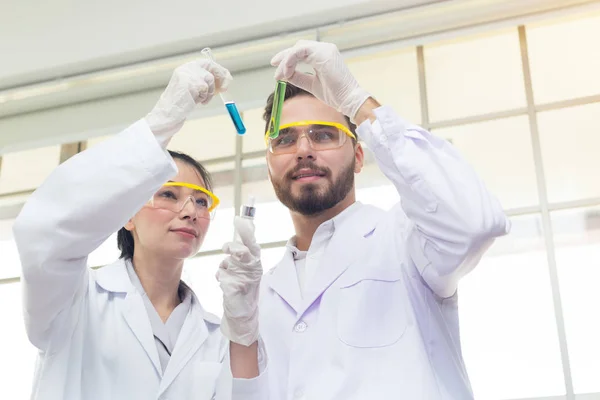 科学家男女在实验室检查化学品. — 图库照片