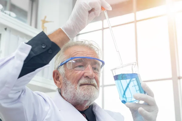 Wissenschaftler senior mit einer Testprobe Chemikalie in der Hand. — Stockfoto