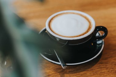 ahşap masada siyah fincan sıcak kahve.