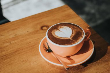 Ahşap masa yumuşak odak üzerinde fincan sıcak kahve, tonda Retro etkisi.