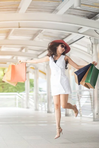 Αρκετά κομψή γυναίκα άλμα και κρατώντας τσάντα για ψώνια στο — Φωτογραφία Αρχείου