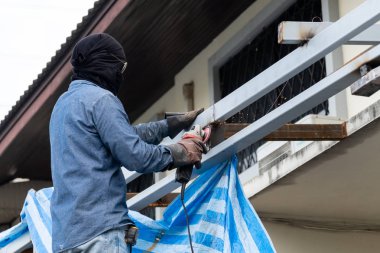 Teknisyenler bir cila ile evin arkasında çelik parlatma vardır