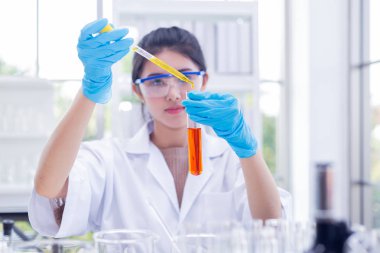 Genç Asyalı kadın bilim adamı araştırma ve laboratuvarda test.