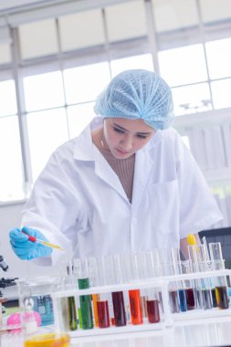 Genç Asyalı kadın bilim adamı araştırma ve laboratuvarda test.