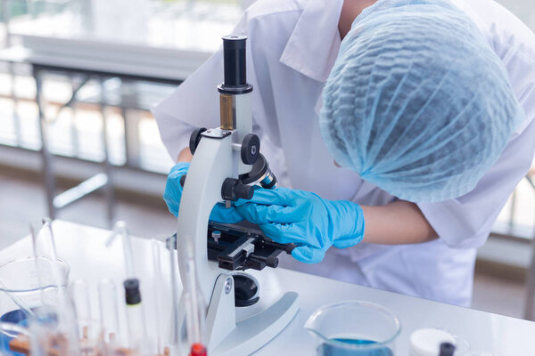 Молодые азиатки-учёные готовят микроскоп для родов
