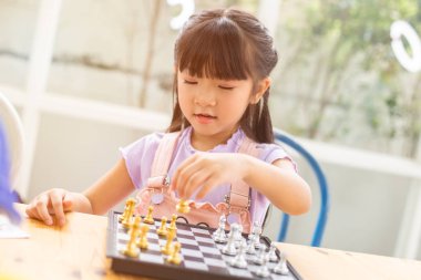 evde ahşap masa zemin üzerinde satranç oynayan bebekler kız.