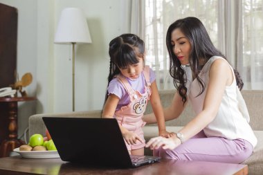 Anne ve kızı evde komik ile dizüstü bilgisayar kullanarak. 