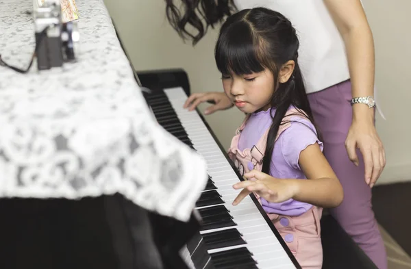 Aziatische familie moeder en dochter spelen piano, muziek concept. — Stockfoto