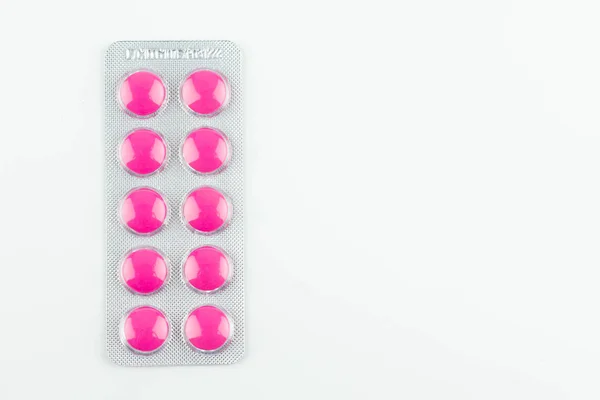 Krabičky z růžových prášků na bílém pozadí. — Stock fotografie