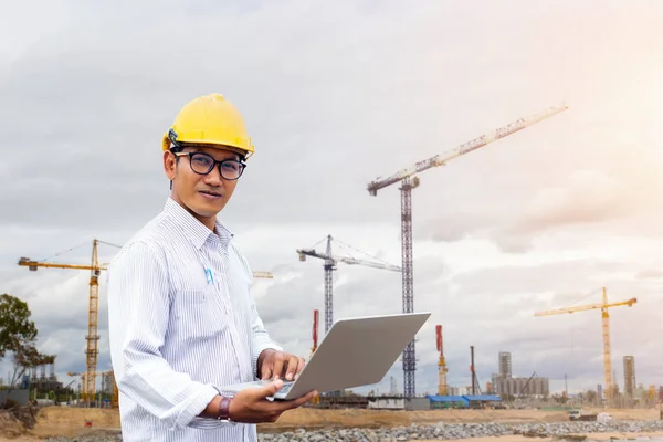 Ingeniero asiático verificando en la construcción del sitio con computadora portátil y con — Foto de Stock