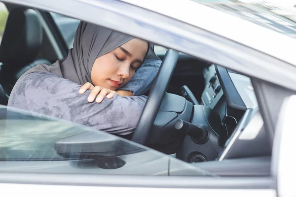 穆斯林妇女睡在方向盘上的汽车. — 图库照片