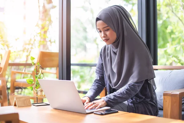 亚洲穆斯林头巾业务妇女工作与笔记本电脑在咖啡馆 — 图库照片
