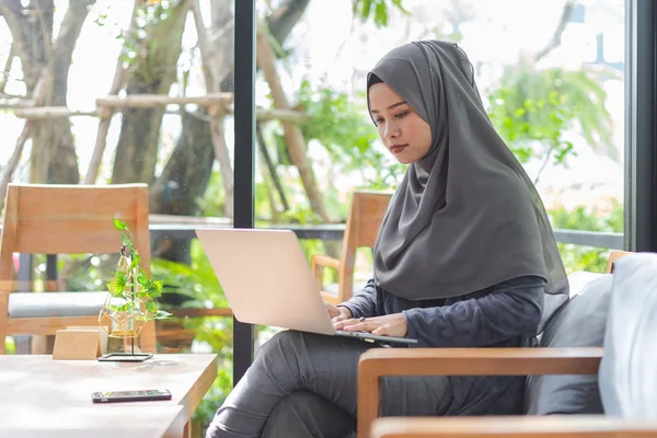 亚洲穆斯林头巾业务妇女工作与笔记本电脑在咖啡馆早上时间. — 图库照片