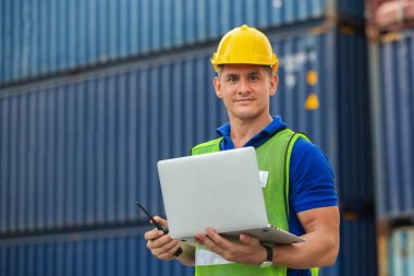 Lojistik ve ithalat şirketi için nakliye alanında Foreman telsiz iletişimi ve dizüstü bilgisayar. iş lojistik kavramı.