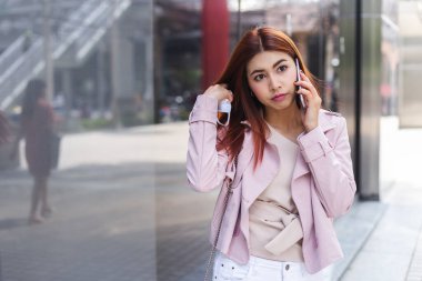 Asyalı genç kadın konuşuyor. Cep telefonu ofisi dışarıda, kopyalama alanı..