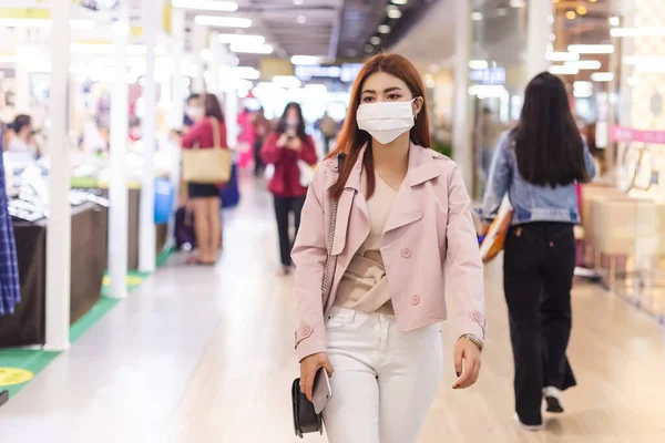 ほこりや感染症のウイルスを防ぐための医療マスクを身に着けているアジアの美しい女性 デパートで女性の歩行 — ストック写真