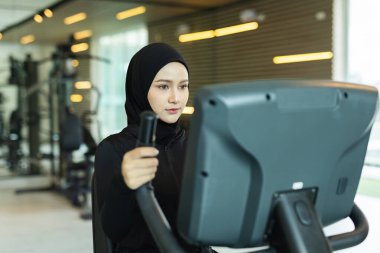 Spor salonlarında kardiyo egzersizi yapan Müslüman kadınlar, modern İslami yaşam tarzını, sağlık eğitimini, sağlık eğitimini, refahı ve aktif yaşam çeşitliliğini sembolize ediyor.