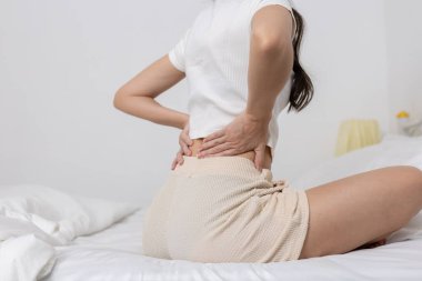 Kadınlar sırt ağrısı, kas zorlanması ya da omurilik rahatsızlığı belirtileri göstererek sırt ağrısıyla oturup baskı yapıyorlar. Duruş, vücut ağrısı ve fiziksel sağlık kavramı.