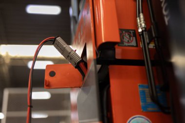 Endüstriyel enerji bağlantısının bir forklift veya depo ekipmanına bağlanması, modern şarj sistemi, elektrik güvenliği ve endüstriyel ortamlardaki enerji bağlantısını vurguluyor.