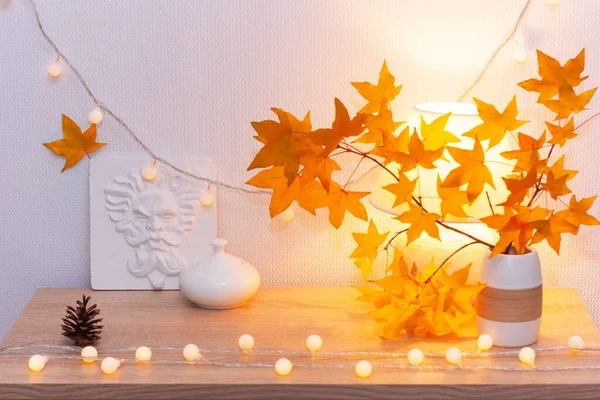 White living room minimalist interior shelf mockup. Autumn decoration room home. Light garland yellow maple leaves lamp