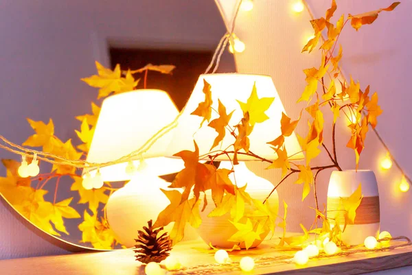 White living room minimalist interior shelf mockup. Autumn decoration. Light garland yellow red maple leaves lamp mirror