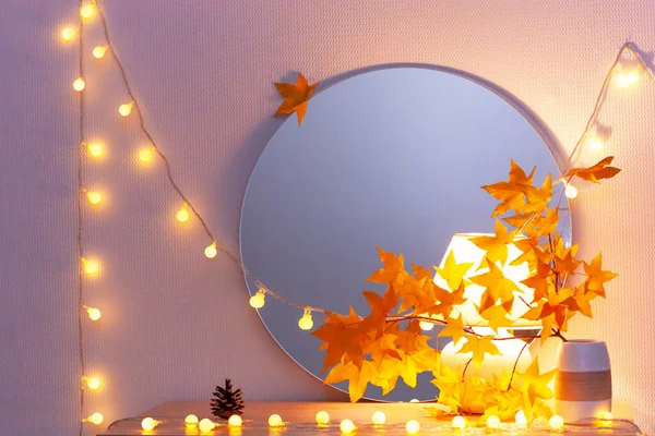 White living room minimalist interior shelf mockup. Autumn decoration. Light garland yellow red maple leaves lamp mirror