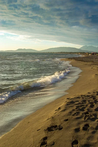 Gün batımında deniz, kumlu plaja sahneleri.
