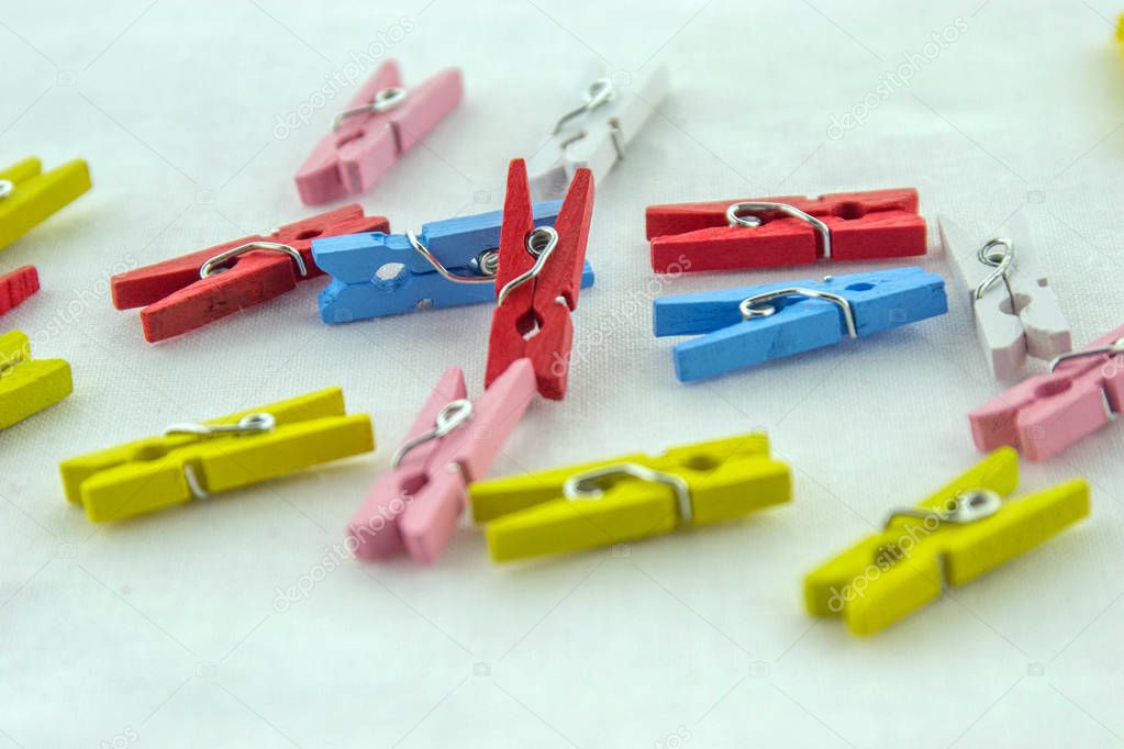 Miniature, wooden, colorful pegs isolated on a white background.