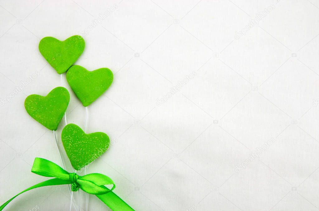 Valentines day decorative background with decorative green hearts with decorative ribbon on a white background. Close up. Top view.