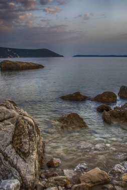 Bir bulutlu gün plaja, taş, su, gökyüzü ve körfezin güzel bir manzara.