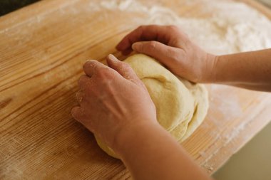 Yaşlı bir kadının eski masada pizza yapmak için para kazanırken çekilmiş bir fotoğrafını çek.