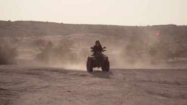 Avrupalı görünümlü güzel bir esmer, Kapadokya 'da kırmızı bir spor avlusuna biniyor.