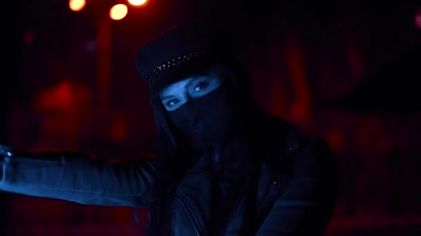 Flicka i svart virus mask tittar på kameran i blått ljus — Stockvideo