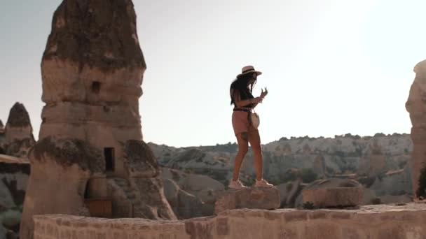 Kaukaska brunetka spacery w górach w gorący letni słoneczny dzień w Cappadocia Turcja — Wideo stockowe