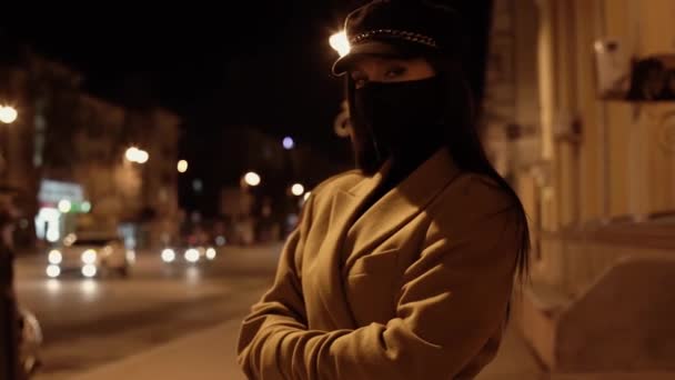 Mooi brunette meisje in zwart virus masker staat op de stoep — Stockvideo