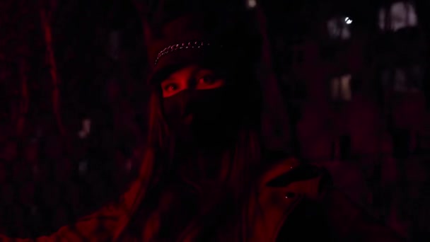 Girl in black virus mask at night in red light stylish street image — Stock Video