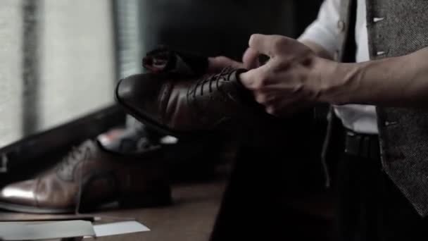 Белый человек закатывает тряпку и чистит коричневые туфли — стоковое видео