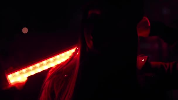 Девушка в черной маске вируса в Кэппи с красной лампой на плечах смотрит в камеру — стоковое видео