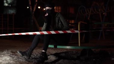 Eskrim bandının arkasındaki siyah virüs maskeli kız.