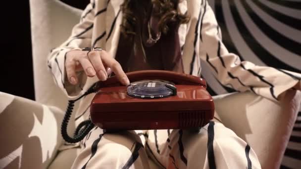 Girl dials a phone number on an old telephone on her finger black ring red lacquered floor — Stock Video