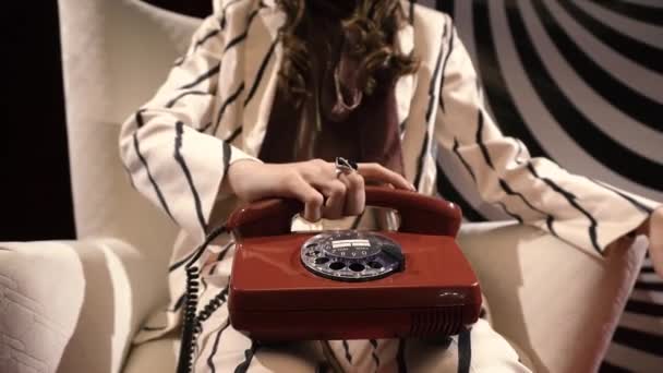 Flicka plockar upp mottagaren av en antik telefon på fingret svart ring — Stockvideo