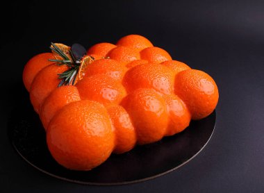 Ayna portakal sır berry mus kek dekore edilmiş bir gıda altınla. Siyah arka plan üzerine.